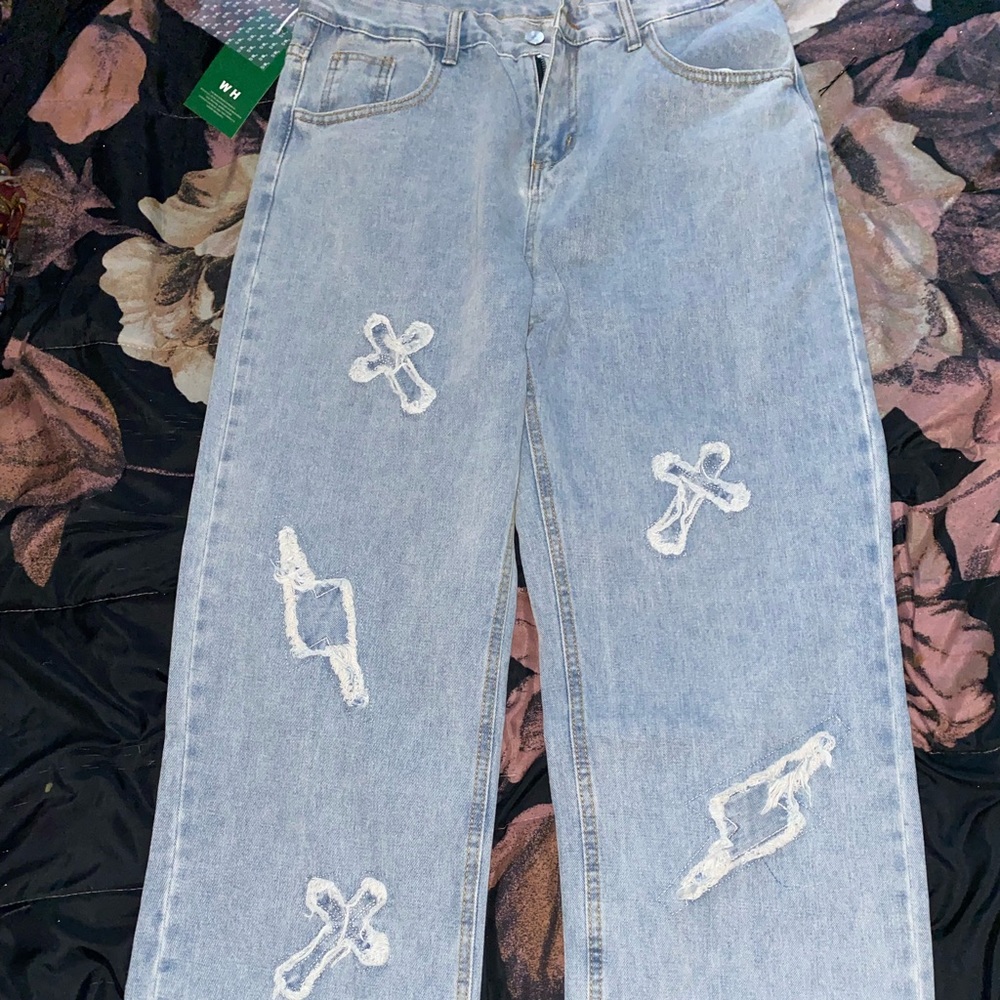 Light washed straight leg jeans with distressed pattern details.
